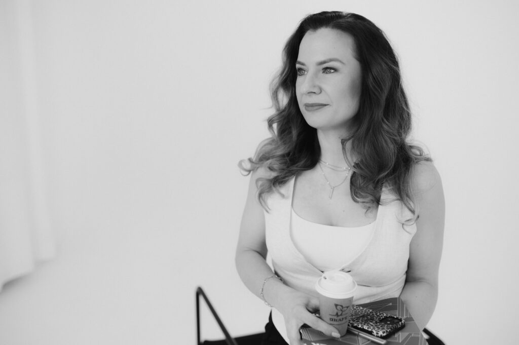 Ing. Hana Biela pózující pro portrét a držící kafe a sešity